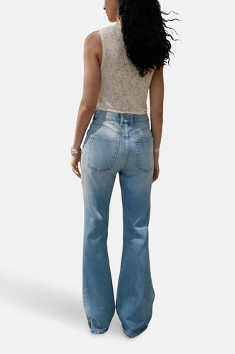 Lichtblauwe flared jeans van MANGO, gezien van achteren, met een effen stof en wijd uitlopende pijpen.
