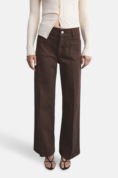 Jeanon de MANGO, avec des jambes larges et des poches, associé à un pull tricoté et des sandales.