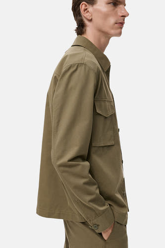 Chemise verte à manches longues de MANGO, avec une poche poitrine et un boutonnière, en vue latérale.