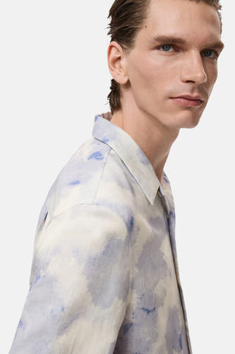 Chemise multicolore à manches courtes de MANGO, avec un motif bleu et beige flou, en vue latérale.