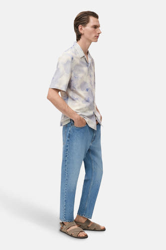 Chemise multicolore à manches courtes de MANGO, portée avec des jeans et des sandales, vue latérale.