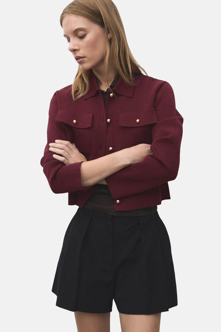 Cardigan Bordeaux de MANGO, avec des manches longues, un col et des boutons dorés.