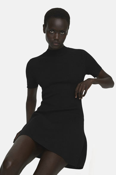 Robe noire à manches courtes de MANGO, vue de derrière, associée à des bottines sombres.