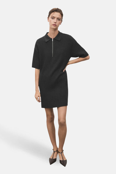 Vêtement gris à manches courtes de MANGO, avec une fermeture éclair argentée sur l'avant et des chaussures ballerine marron.