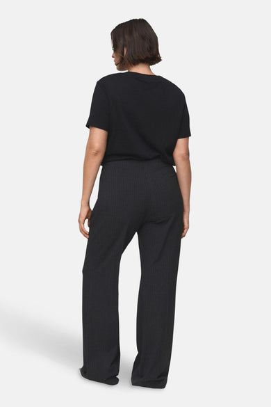 Pantalon gris MANGO, avec un motif subtil de rayures de craie et des jambes larges, vu de derrière.