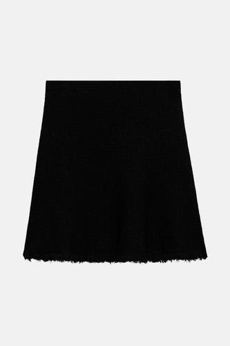 Jupe courte noire de MANGO, avec un volant et une texture lisse.