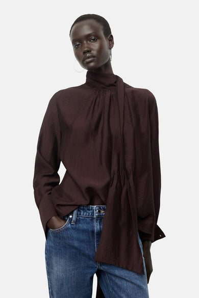 Blouse brune à longues manches de MANGO, avec une légère texture et une petite ouverture dans le dos du col.