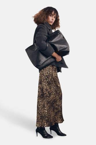 Multikleurige rok van MANGO, met een panterprint en gecombineerd met een grijze jas en zwarte laarsjes.
