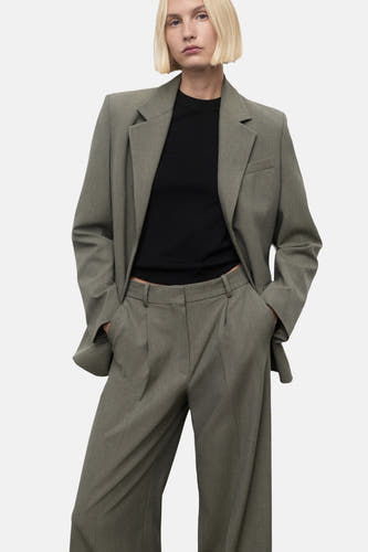 Pantalon vert de MANGO, avec des jambes larges et des poches, porté avec un t-shirt noir et un blazer.