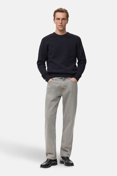 Sweat-shirt bleu marine avec col rond de MANGO, porté avec des jeans gris et des chaussures noires.