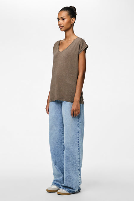 T-shirt brun à manches courtes de PIECES®, porté avec des jeans larges et des baskets, en vue latérale.