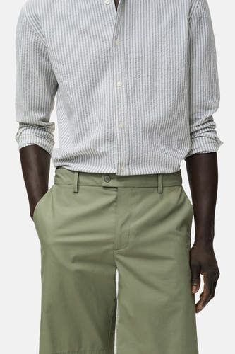 Short vert de MANGO, combiné avec un chemisier rayé, vu dans une photo cropée.
