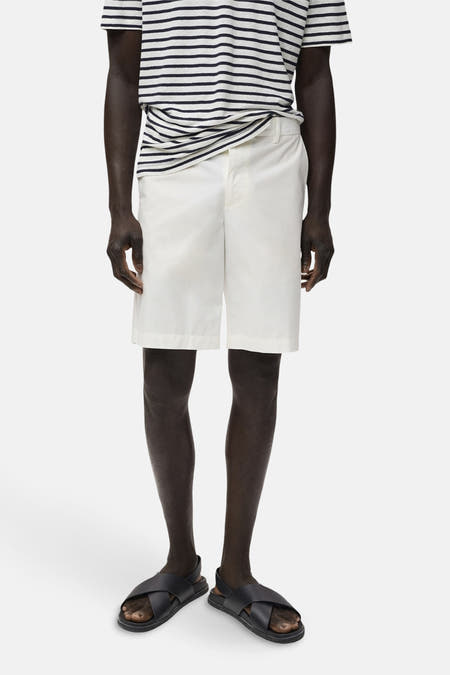Short blanc de MANGO, associé à un t-shirt rayé et des sandales noires.