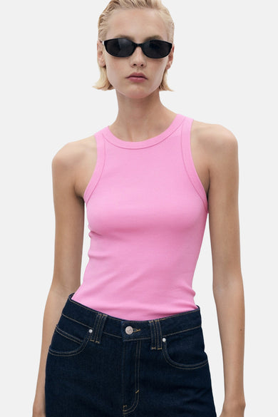 Maillot de corps rose de MANGO, porté avec un jean foncé et des lunettes de soleil.