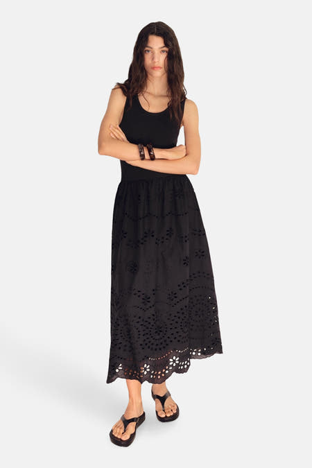 Robe sans manches noire de MANGO, avec des détails brodés et une jupe longue et fluide.