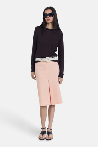 Robe rose 3/4 de MANGO, avec une fente à l'avant, combinée avec un ceinture, un pull et des sandales.