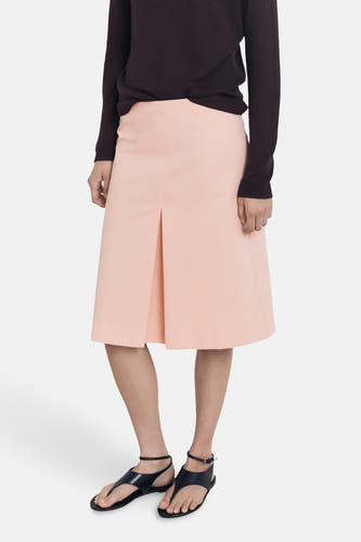 Robe rose 3/4 de MANGO, associée à une chemise sombre et des sandales noires.