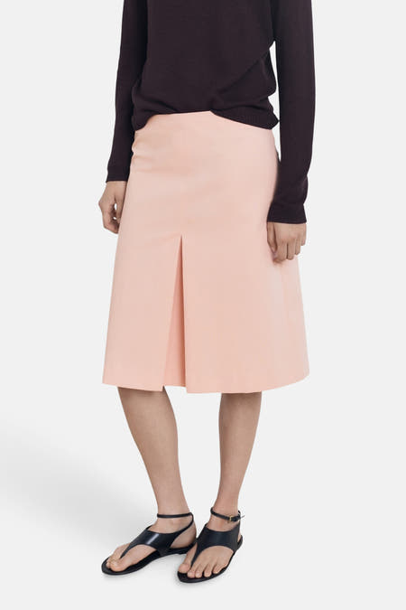 Robe rose 3/4 de MANGO, associée à une chemise sombre et des sandales noires.