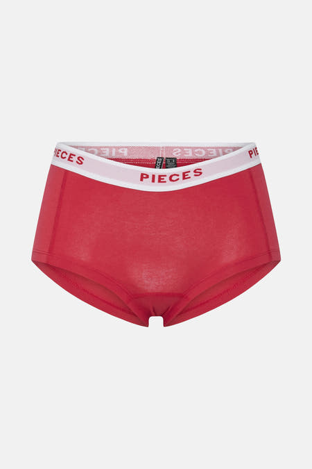 Shorty rouge de PIECES avec une bande logo blanche.