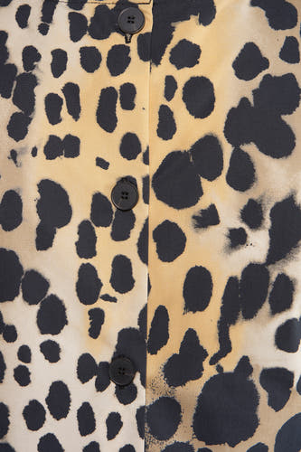 Blouse sans manches beige de MANGO, avec des taches sombres et une fermeture à boutons.