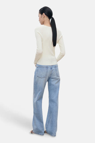 T-shirt blanc avec col rond de MANGO, porté avec des jeans larges, vu de l'arrière.