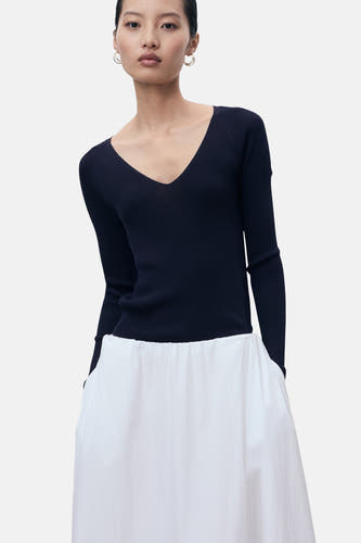 T-shirt bleu avec col rond de MANGO, associé à une jupe blanche à poches.