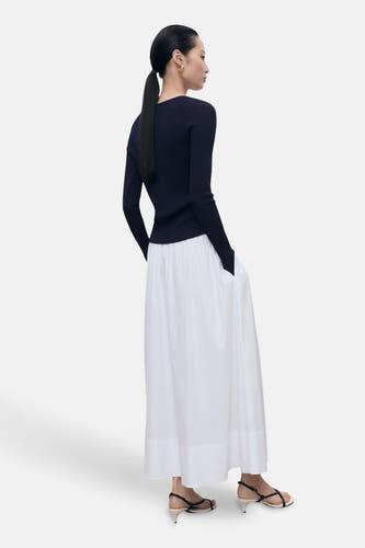 T-shirt bleu avec col rond de MANGO, associé à une longue jupe blanche et des sandales à brides.