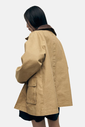 Manteau court beige de MANGO, avec un col marron et une poche sur la partie avant, vu d'en arrière.