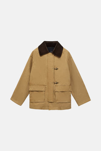 Manteau court beige de MANGO, avec un col marron et des poches brodées à l'avant.