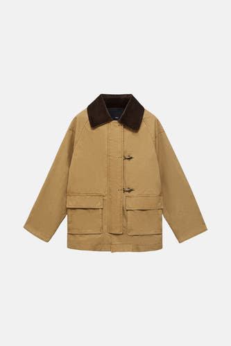 Manteau court beige de MANGO, avec un col marron et des poches à l'avant.