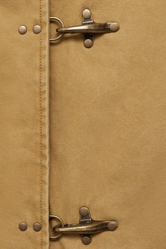 Manteau court beige de MANGO avec des fermetures métalliques et une poche brodée.