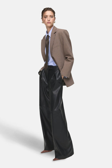 Pantalon de costume noir MANGO, avec des jambes larges, à porter avec un blazer et une chemise rayée.