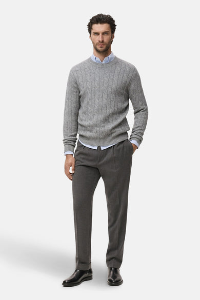 Sweat-shirt gris à col rond de MANGO, avec un motif côtelé, porté avec une chemise bleu clair et un pantalon gris.