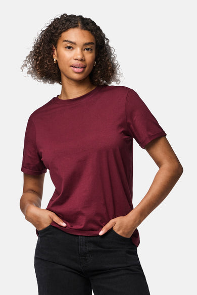 T-shirt Bordeaux à manches courtes de PIECES®, porté avec un pantalon noir et un chapeau de soleil.