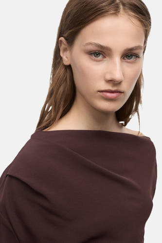 Blouse brune à longues manches de MANGO, avec une encolure drapée.