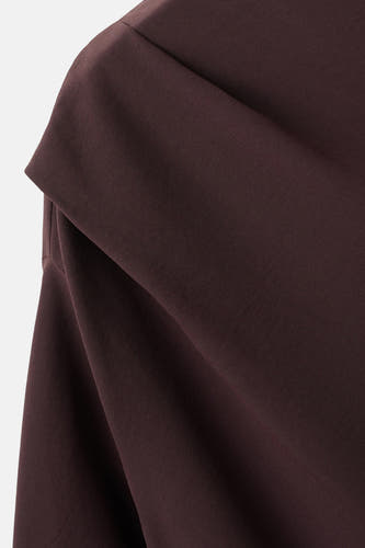 Blouse brune à manches longues de MANGO, avec une ligne de col drapée et une subtile texture.