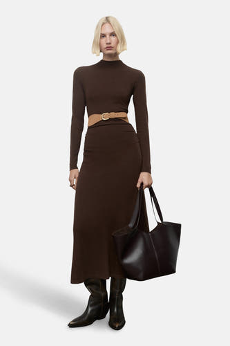 Robe brune à longues manches de MANGO, avec des détails plissés sur les côtés et des talons.
