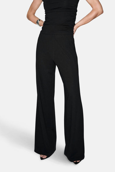 Pantalon noir de MANGO, avec des jambes larges et une ceinture élastique, vu de derrière.