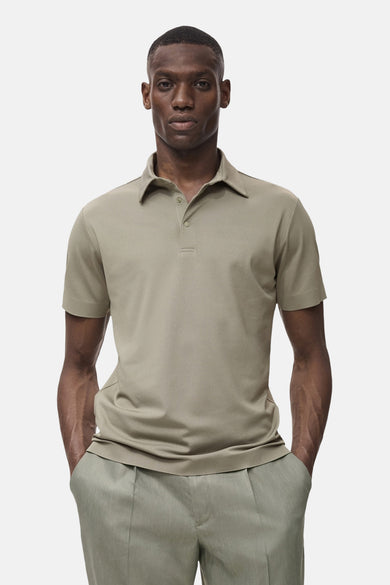 Kaki polo avec des manches courtes de MANGO, porté avec un pantalon léger plissé.