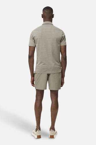 Polo vert de mantes courtes M MANGO, avec une classagie un et porté avec des shorts kaki et des baskets basses.