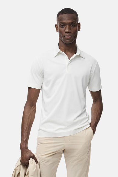 Polo écru à manches courtes de MANGO, de couleur unie et porté avec un pantalon kaki.