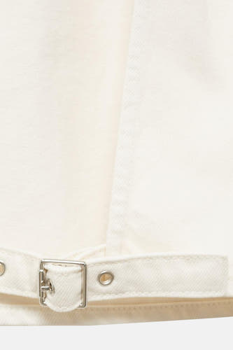 Blouse écru de MANGO, avec une ceinture à boucle argentée.