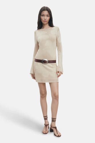 Manteau beige à longues manches de MANGO, avec imprimé floral et ceinture brune et sandales.