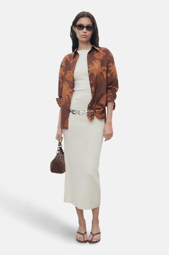 T-shirt MANGO marron à manches longues avec un motif de palmier tropical, porté sur une robe blanche.