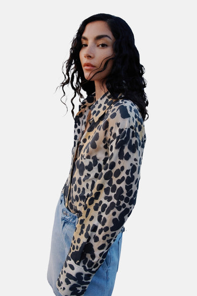 Chemise multicolore (manches longues) de MANGO, avec imprimé léopard, portée avec un short en denim bleu.