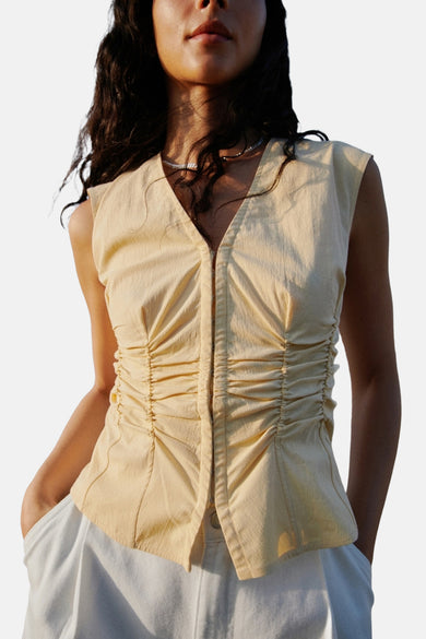 Blouse sans manches MANGO, avec des détails froissés et une chaîne argentée.