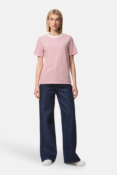 T-shirt rayé rouge avec manches courtes de PIECES®, porté avec des jeans bleus marine larges et des baskets blanches.