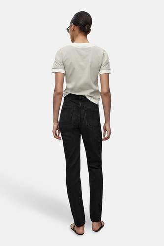 Jean mom marron clair de MANGO, vu de derrière, associé à un T-shirt gris clair.