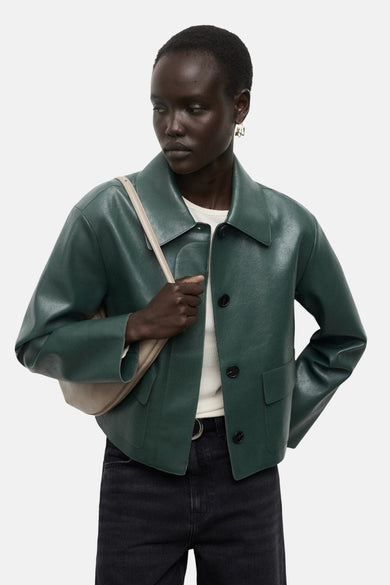 Manteau court vert de MANGO, vu vu de l'arrière, associé à un jean noir et des chaussures noires.