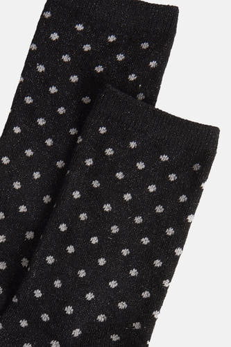 Chaussettes noires de PIECES® avec des taches brillantes sur un fond lisse, gros plan.